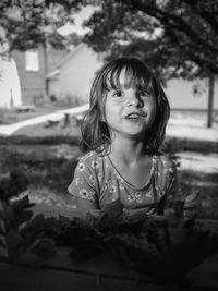 Close-up of smiling girl looking away while sitting at park