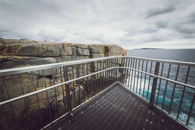 Railing by sea against sky