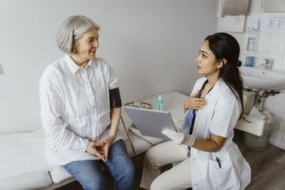 Female doctor examining patient at home