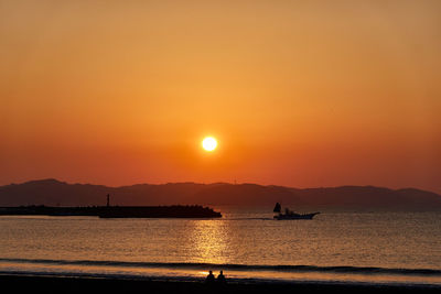 Scenic view of sea against orange sky