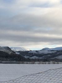 Scenic view of lake by mountains against sky