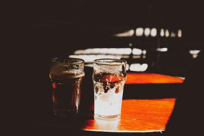 Close-up of wineglass on table against black background