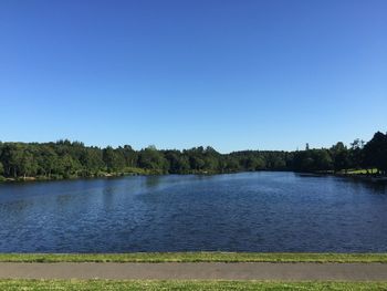 Scenic view of lake against clear blue sky