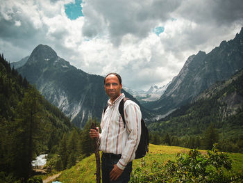 Young man standing on mountain against sky