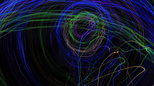 Close-up of light painting against black background using long exposure 