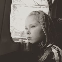 Close-up of girl looking through train window