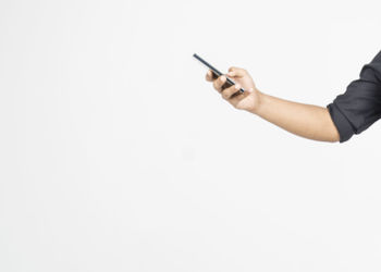 Midsection of man using smart phone against white background