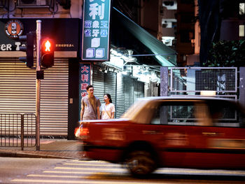 Blurred motion of people walking on road in city