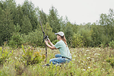 Side view of man sitting on field