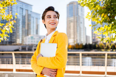 Portrait of young businesswoman standing in city