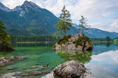 Scenic view of lake by mountains against sky