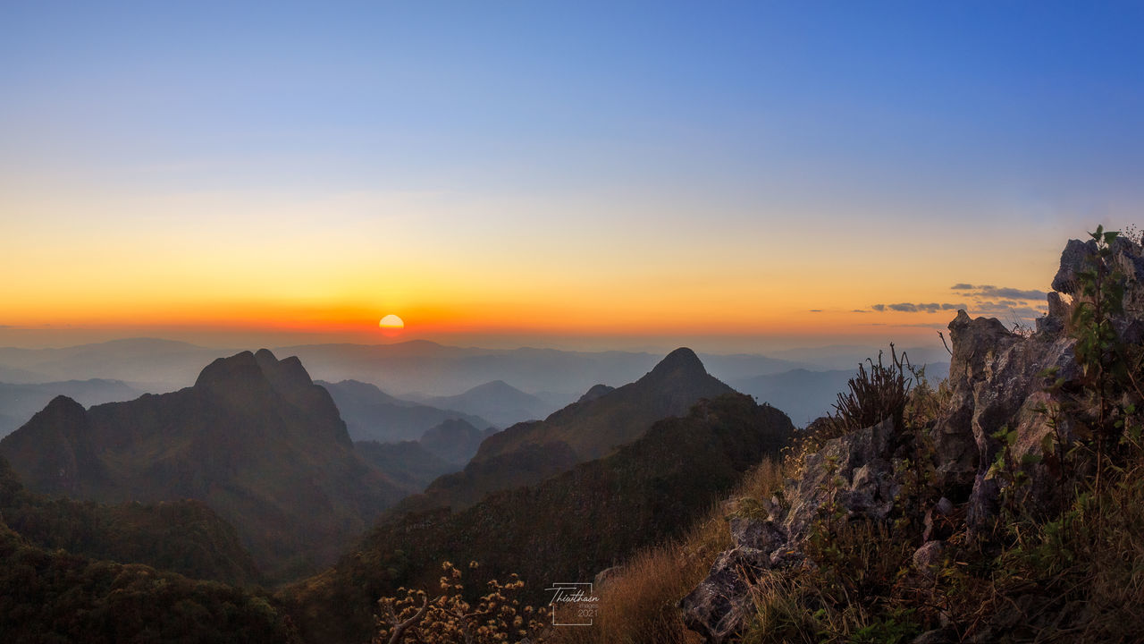 sky, scenics - nature, sunset, environment, landscape, mountain, beauty in nature, nature, land, travel, sun, mountain range, travel destinations, tranquility, panoramic, tree, wilderness, dawn, plant, twilight, cloud, tranquil scene, tourism, mountain peak, outdoors, fog, no people, forest, sunlight, rock, horizon, non-urban scene, idyllic, blue, dramatic sky, valley, vacation, trip, activity, ridge, holiday, urban skyline, architecture, rural scene, horizon over land, orange color, leisure activity