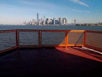 Modern cityscape by sea against sky