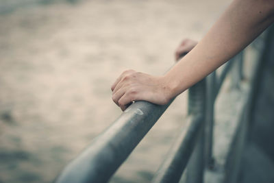 Close-up of woman hand holding railing outdoors