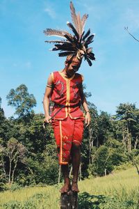 Low angle view of woman standing against trees