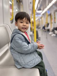 Portrait of cute boy sitting on subway, mtr in hong kong