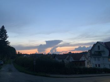 Houses and buildings against sky during sunset