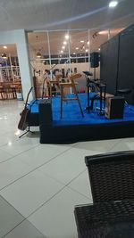 Empty chairs and tables in illuminated building