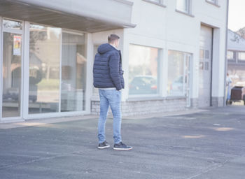 Full length rear view of man standing in city