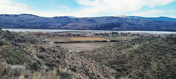 Scenic view of dam and mountains against sky