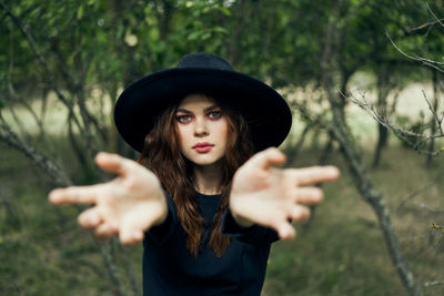 Portrait of young woman wearing hat standing outdoors