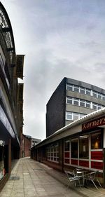 Buildings in city against cloudy sky