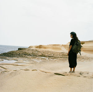 Full length of woman standing on beach against sky