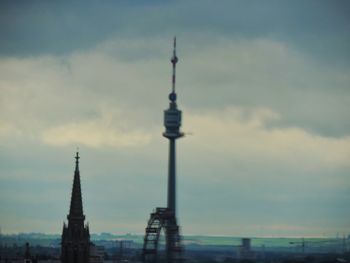 Eiffel tower against cloudy sky