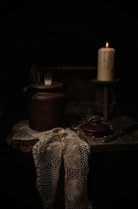 Close-up of lit candles on table against black background