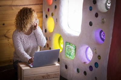 Woman using laptop by window