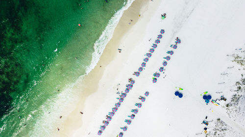 Aerial view of people and rows of sun umbrellas on fort walton beach, fl in july.
