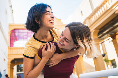 Happy friends standing against the wall