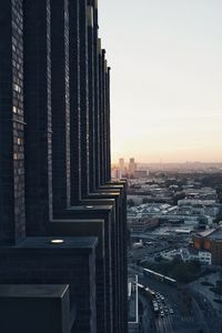 Modern buildings in city against sky during sunset