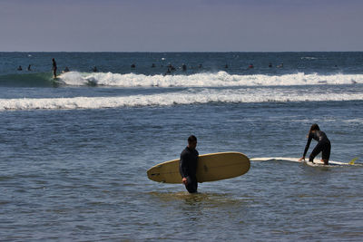 People on beach against sky