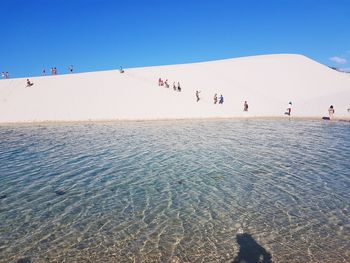 People at beach against sky