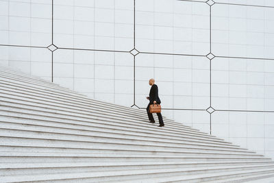 Rear view of man walking on footpath