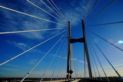 Low angle view of suspension bridge against cloudy sky