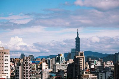 View of cityscape against cloudy sky