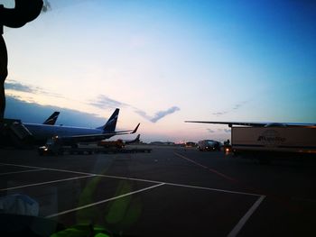 Airplane flying over airport runway against sky