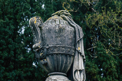 Close-up of old statue against trees