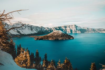 Scenic view of sea by mountains against sky