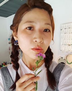 Close-up portrait of happy girl holding flower