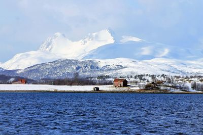 Scenic view of sea by mountains against sky