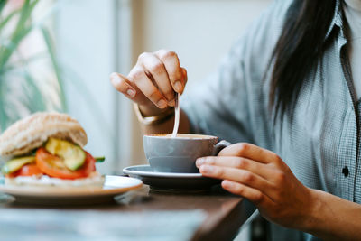 Woman drinking a cup of coffee in a coffee shop