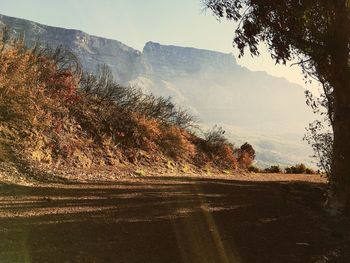 Road by mountains against clear sky