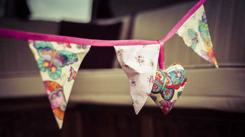 Close-up of multi colored flags hanging on paper