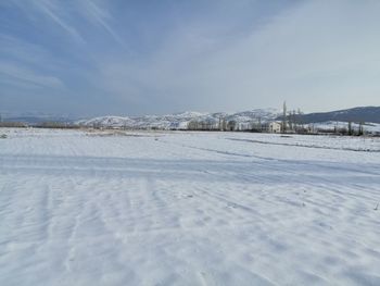 Snow covered land against sky