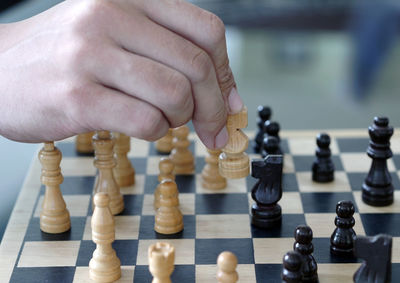 Cropped hand of person playing chess 