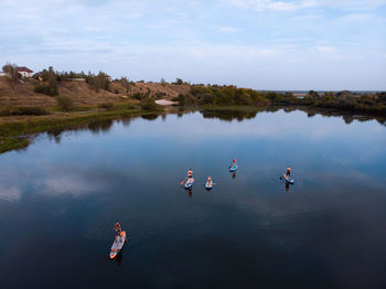 Young attractive people on stand up paddle board in the russian lake on the sunset. 