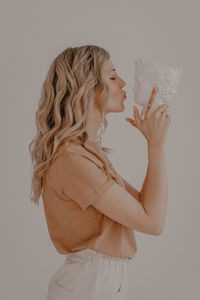 Side view of a woman holding hands over white background